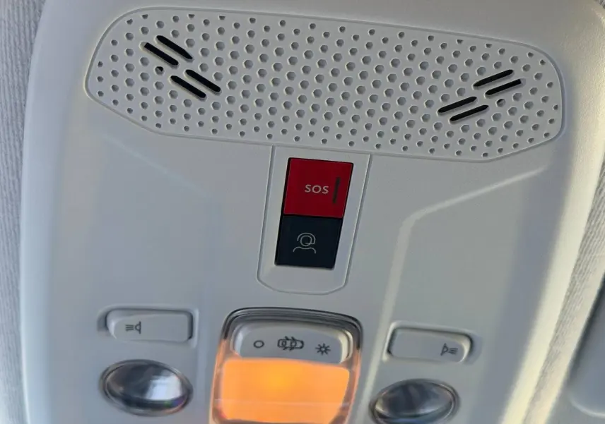 Détail du plafonnier intérieur gris clair avec bouton SOS rouge et éclairage ambre allumé sur Peugeot 208 1.2 100ch Allure.