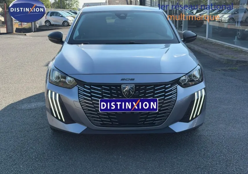 Vue avant frontale de la Peugeot 208 1.2 100ch gris Artense avec feux LED verticaux distinctifs et calandre noire.