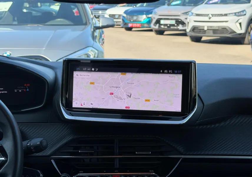 Vue intérieure centrée sur l'écran tactile du tableau de bord de la Peugeot 208 gris Artense, avec navigation affichée.