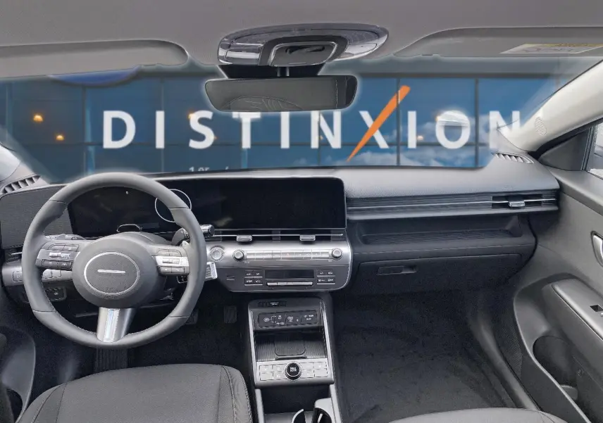 Vue intérieure avant du Hyundai Kona 2025 gris, tableau de bord moderne avec écran large et volant multifonction cuir.