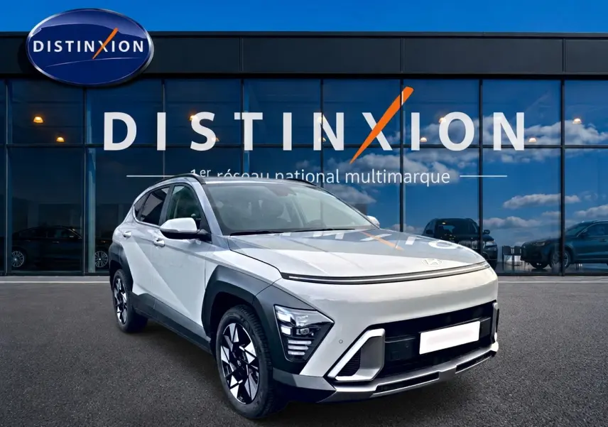 Hyundai Kona 2025 gris en 3/4 avant droit avec feux LED et jantes alliage devant showroom Distinxion.