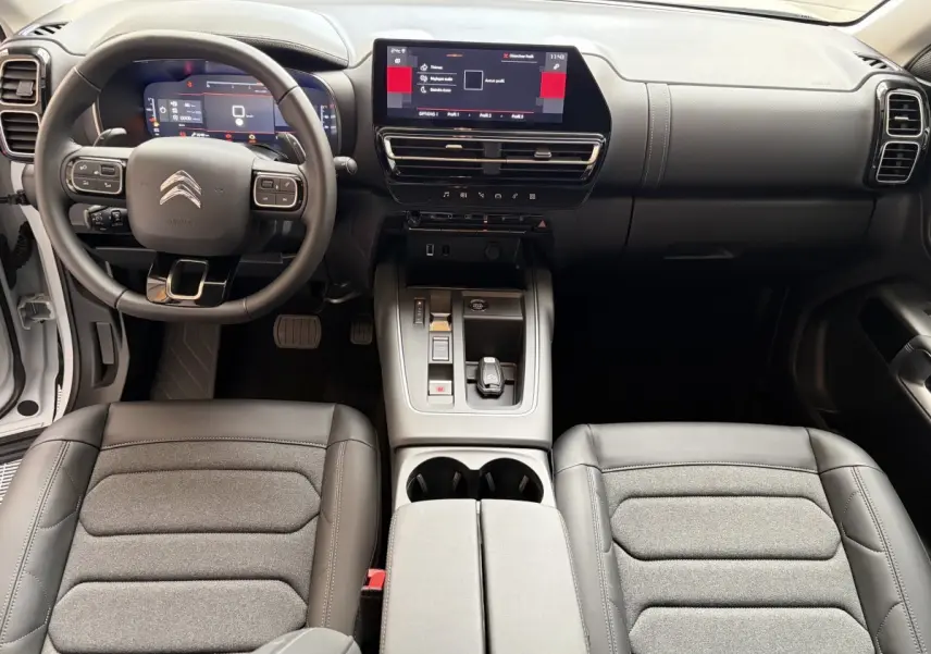 Intérieur du Citroën C5 Aircross 2025, vue avant centrée sur tableau de bord et volant multifonctions cuir noir.