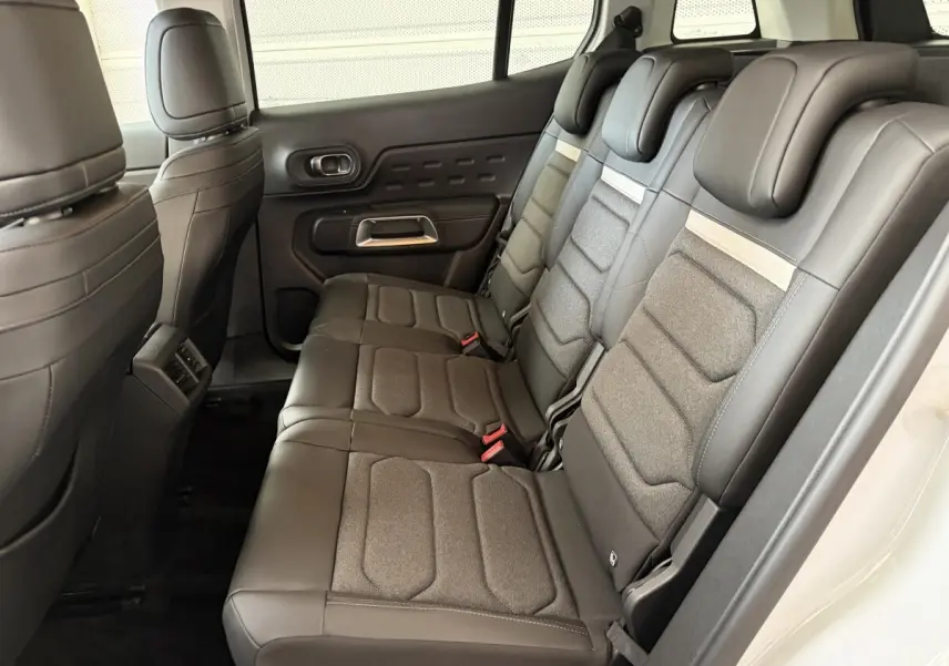 Vue latérale droite de l’intérieur arrière du Citroën C5 Aircross blanc, sièges 3 places en cuir et tissu gris.