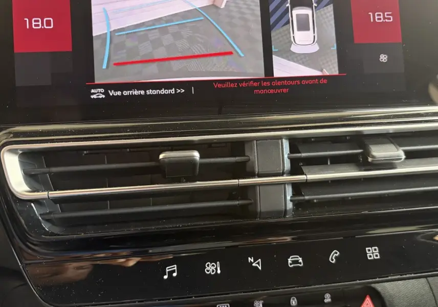 Vue rapprochée de l’écran tactile central du tableau de bord du Citroën C5 Aircross blanc, affichant la caméra de recul et l’aide au stationnement.