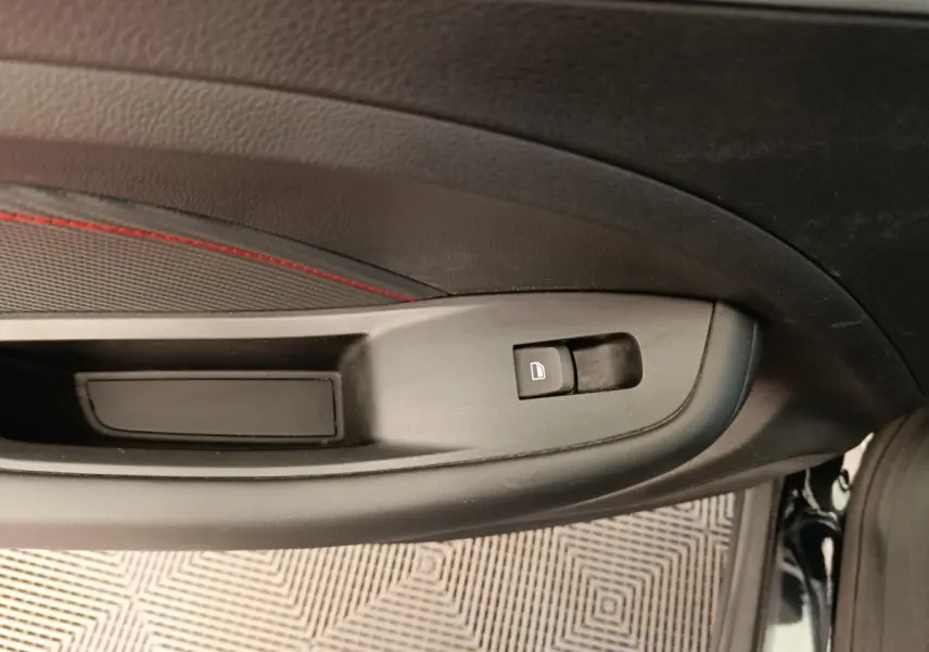 Détail de la commande de verrouillage sur la porte intérieure côté conducteur d’un MG ZS Luxury noir 2024.