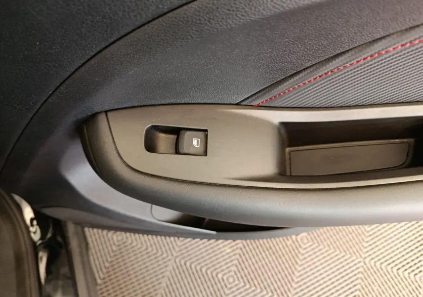 Détail de la commande de lève-vitre sur la porte intérieure côté conducteur du MG Motor ZS Luxury noir 2024.