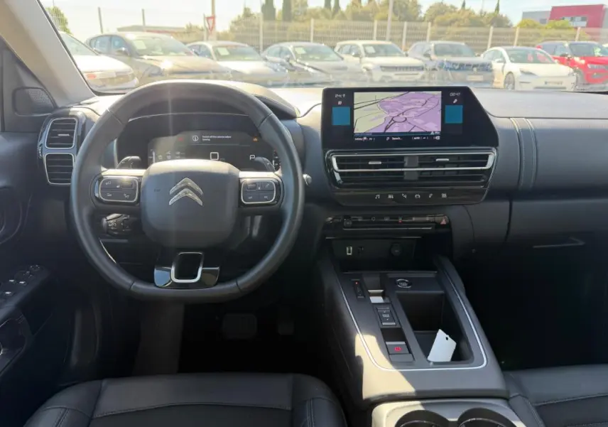 Vue intérieure centrée sur le volant et la console centrale du Citroën C5 Aircross hybride noir 2024 avec écran tactile et commandes intégrées.