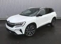 Renault Austral E-Tech Full Hybrid 200 Iconic blanc nacré avec toit noir, vue 3/4 avant sur sol mouillé