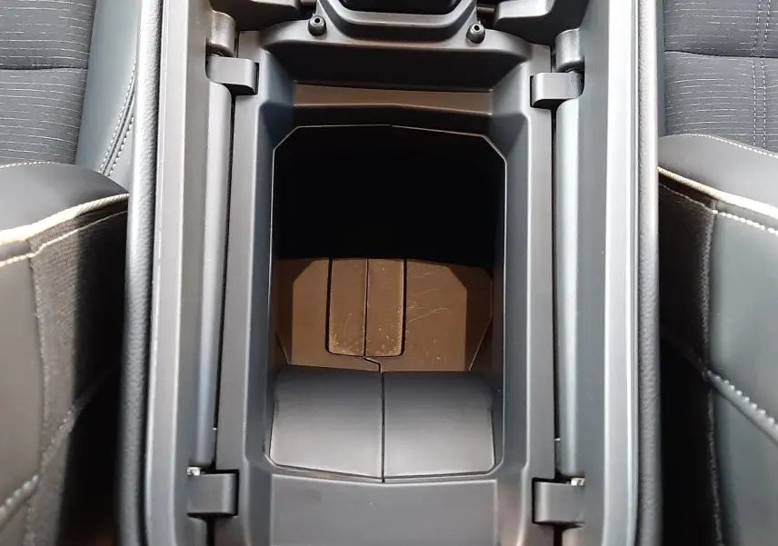 Vue plongeante sur le rangement central noir entre les sièges du Renault Austral E-Tech Full Hybrid 200 Iconic 2025.