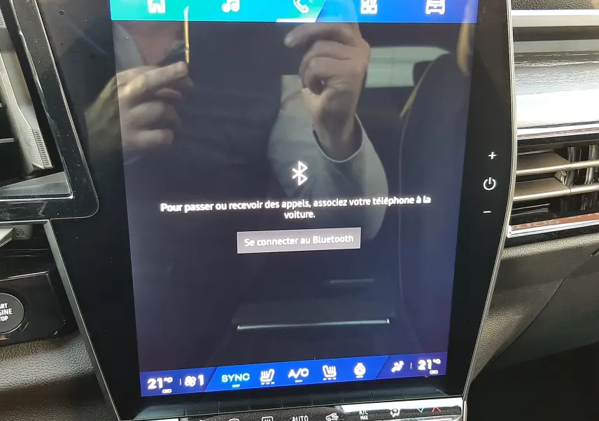 Écran tactile central du Renault Austral E-Tech 2025, affichant la connexion Bluetooth, intérieur noir visible.