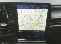 Écran tactile central du Renault Austral E-Tech 2025 affichant une carte de navigation, intérieur noir moderne.