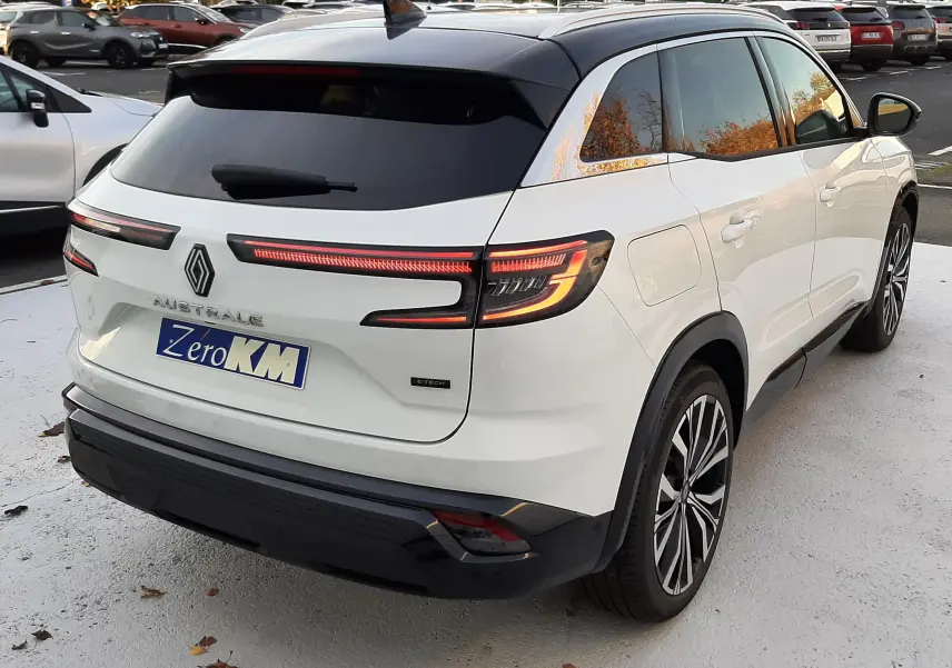 Vue 3/4 arrière droite du Renault Austral E-Tech Full Hybrid 200 Iconic blanc nacré avec toit noir et feux LED distinctifs.
