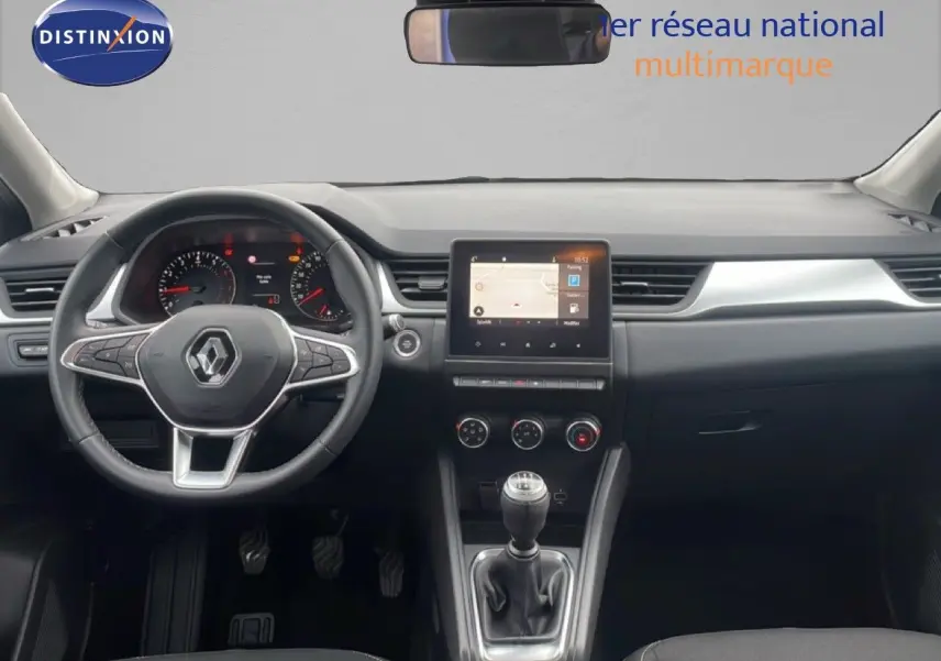 Vue intérieure frontale du tableau de bord du Renault Captur gris Cassiopée, avec volant multifonction et écran tactile central.