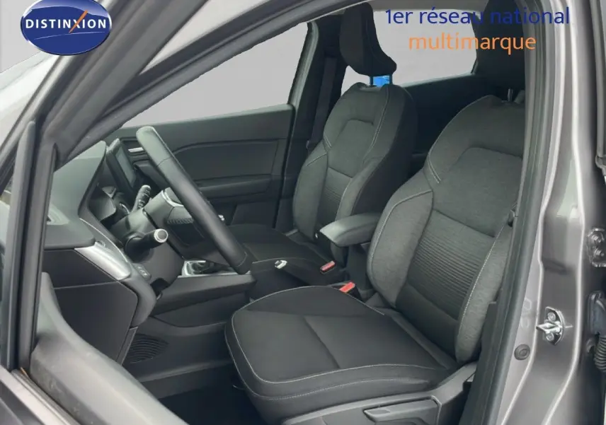 Vue intérieure côté conducteur du Renault Captur gris cassiopée métal, montrant les sièges tissu et le volant multifonction.