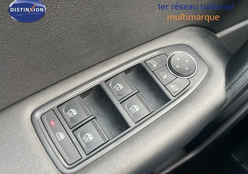 Gros plan sur les commandes des vitres électriques côté conducteur d’un Renault Captur gris Cassiopée métal.