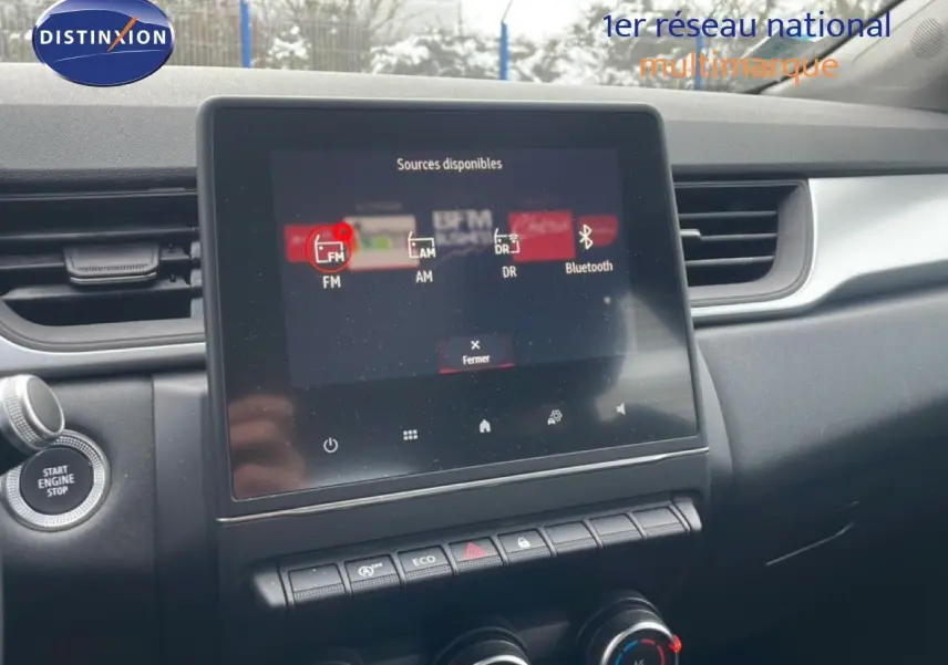 Vue intérieure centrée sur l'écran tactile multimédia et la console centrale du Renault Captur gris Cassiopée métal.