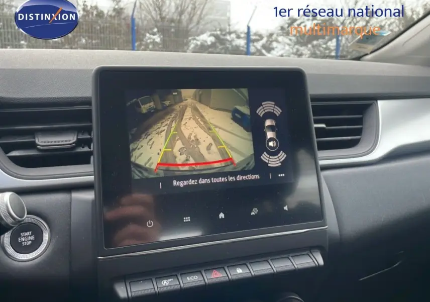 Vue intérieure du tableau de bord du Renault Captur gris Cassiopée, avec écran tactile affichant la caméra de recul.