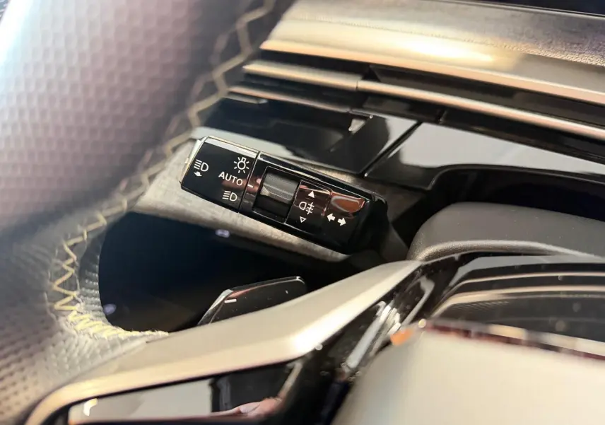 Gros plan sur la commande des feux et clignotants côté gauche du volant du Peugeot 5008 Hybrid 145 GT 2025.