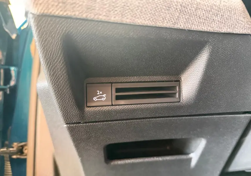 Détail du bouton d'ouverture du hayon électrique sur la porte côté gauche d'un Peugeot 5008 Hybrid 145 bleu obsession.