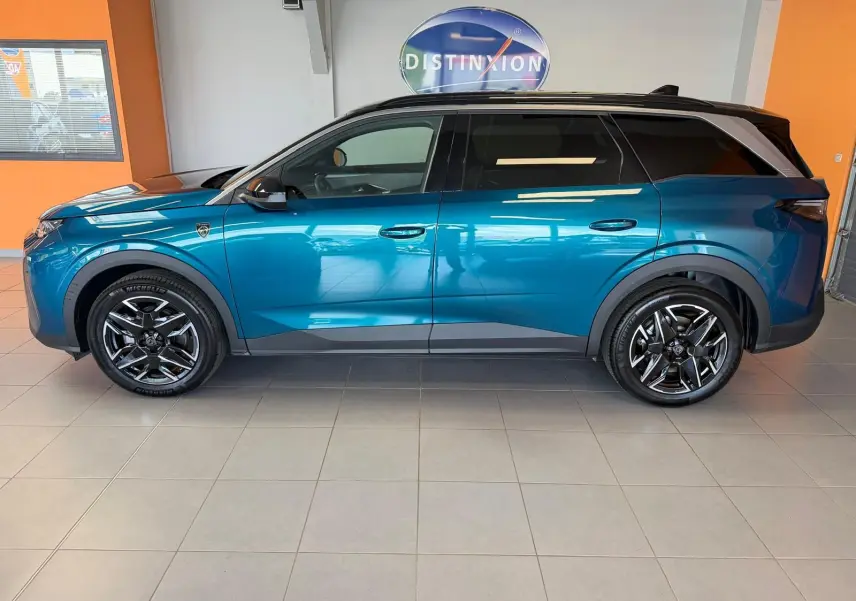 Profil droit du Peugeot 5008 HYBRID 145 GT 2025 en bleu obsession avec toit noir et jantes alliage 19 pouces.