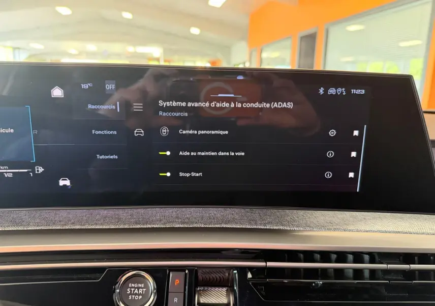 Vue rapprochée de l’écran central HD 21’’ du Peugeot 5008 Hybrid 145 GT, avec interface d’aide à la conduite affichée.