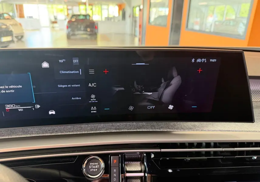 Vue rapprochée de l’écran tactile central du Peugeot 5008 Hybrid 145 GT 2025, affichant la climatisation et les sièges.