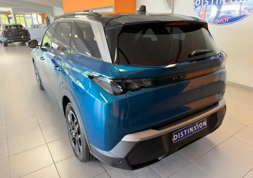 Vue 3/4 arrière droite du Peugeot 5008 Hybrid 145 GT bleu Obsession avec toit noir et jantes alliage 19 pouces.
