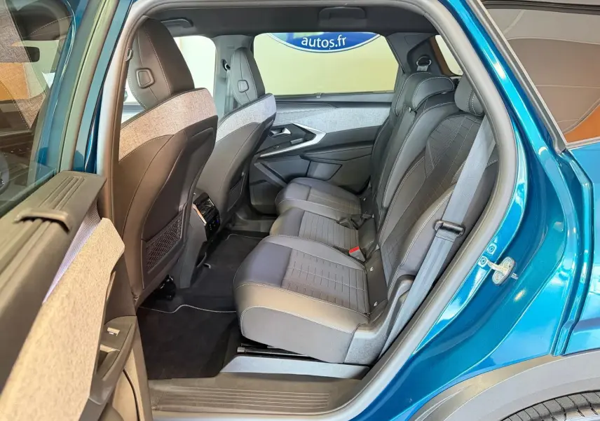 Vue côté gauche arrière sur l’intérieur du Peugeot 5008 Hybrid 145 GT bleu Obsession, sièges tissu/tepp noir et gris.