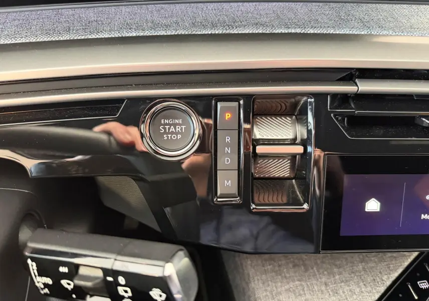 Gros plan intérieur sur la console centrale du Peugeot 5008 Hybrid 145 GT, avec bouton Start/Stop et sélecteur de vitesses.