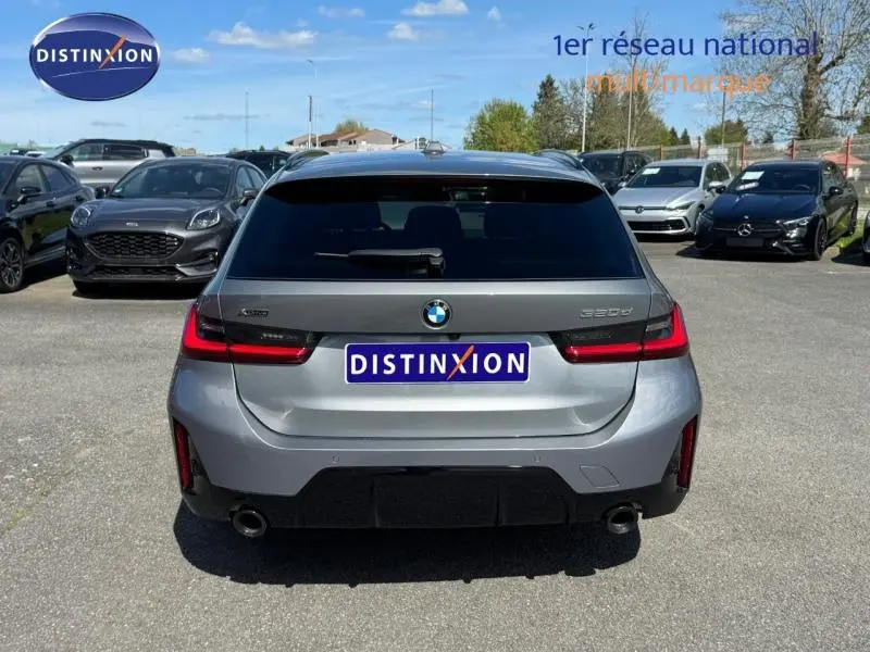 Vue arrière d'une BMW Série 3 320dA xDrive M Sport 2025 en gris métallisé Skyscrapergrau, avec feux LED et double sortie d'échappement.