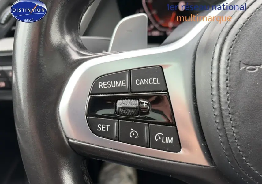 Gros plan sur les commandes du volant cuir noir de la BMW Série 2 Gran Coupé F44, boutons de régulateur de vitesse visibles.