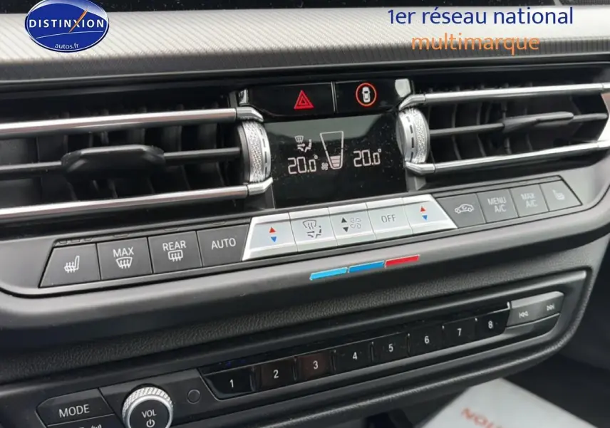 Détail du tableau de bord de la BMW Série 2 Gran Coupe gris, montrant la console centrale avec commandes climatisation et radio.