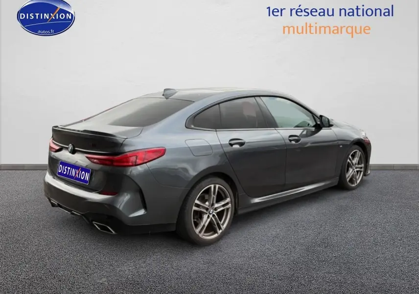 BMW Série 2 Gran Coupe gris vue 3/4 arrière droit avec jantes alu et sorties d'échappement chromées.