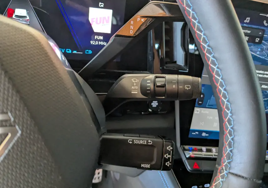 Vue rapprochée de la colonne de direction du Renault Espace VI noir étoile, avec commandes au volant et écran digital.