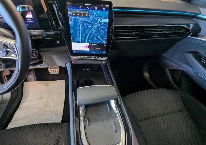 Vue intérieure avant du Renault Espace VI E-Tech noir étoile, avec grand écran tactile central et sièges en tissu noir.