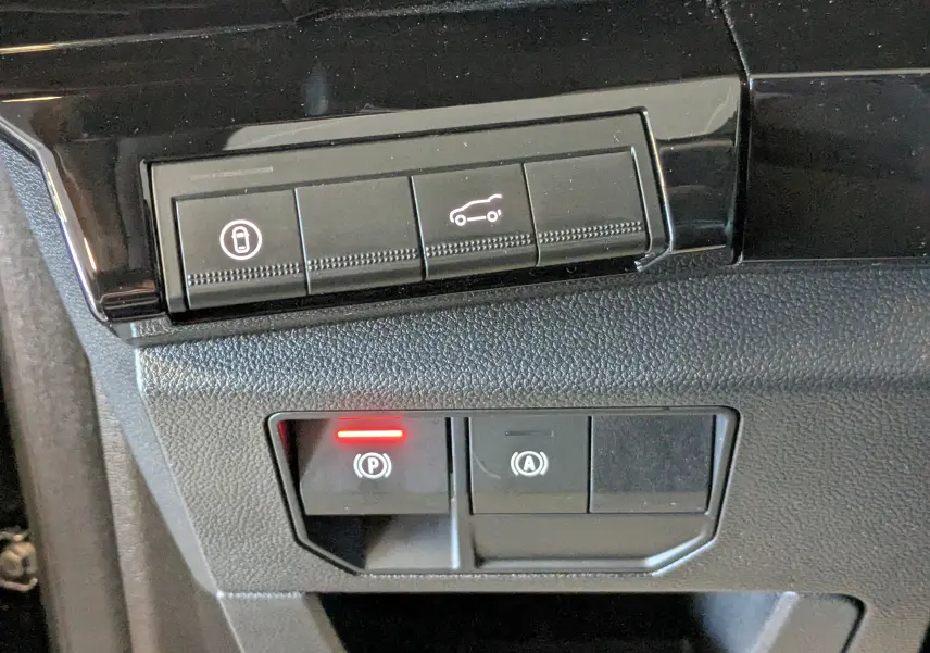 Gros plan sur les commandes intérieures du Renault Espace VI E-Tech, boutons de verrouillage et ouverture coffre visibles.