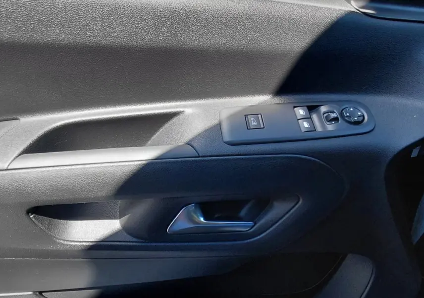 Gros plan sur la porte avant gauche du Citroën Berlingo blanc 2025, avec commandes électriques et poignée intégrée.