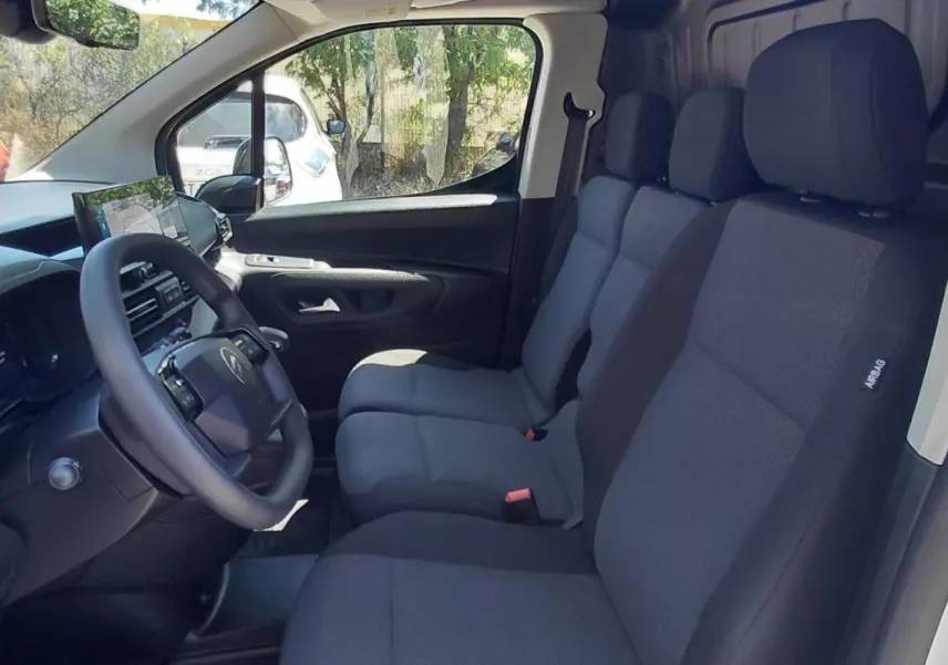Vue intérieure côté conducteur du Citroën Berlingo blanc 2025, montrant les sièges avant et le volant multifonctions.