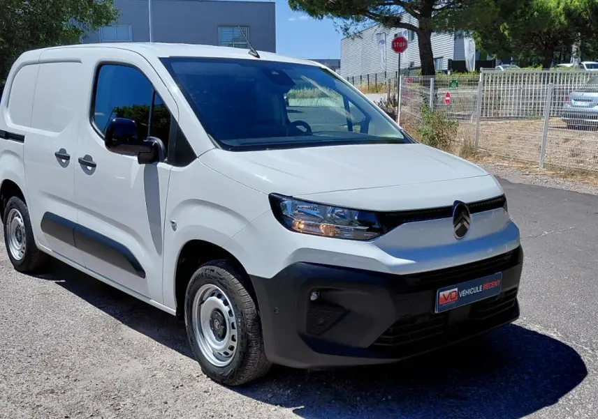 Vue 3/4 avant gauche d’un Citroën Berlingo blanc 2025 avec porte latérale et jantes acier 15 pouces.
