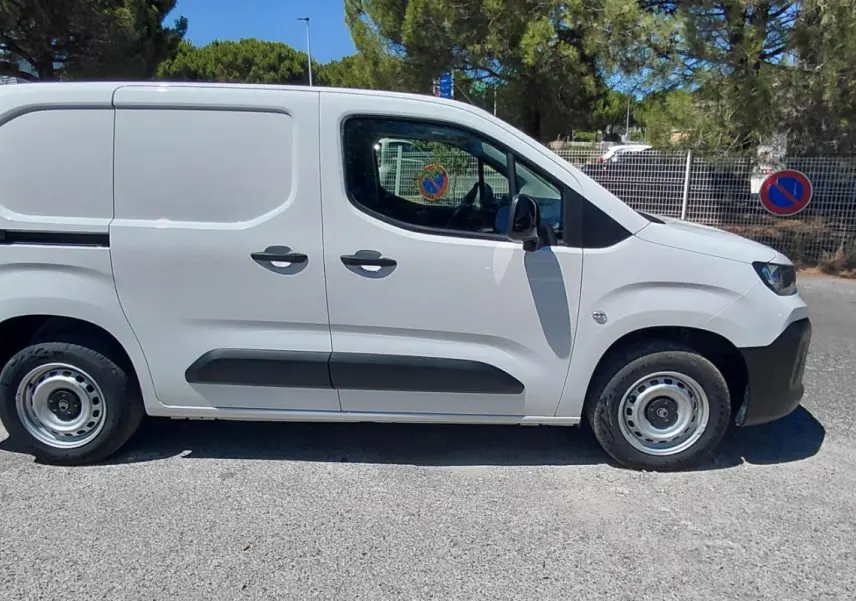 Vue de profil côté gauche d'un Citroën Berlingo blanc 2025, fourgon utilitaire avec porte latérale et jantes acier 15 pouces.