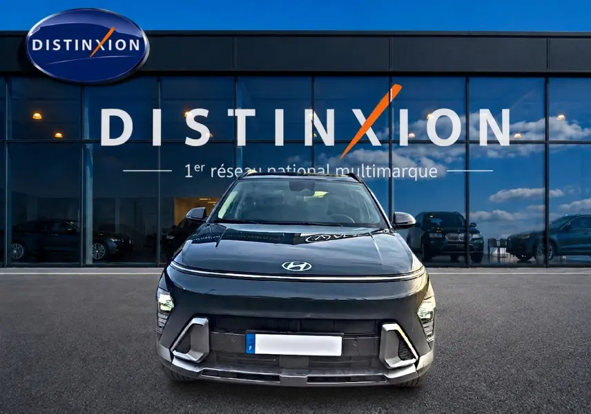 Vue avant d'une Hyundai Kona gris ecotronic avec calandre et feux LED, stationnée devant une vitrine Distinxion.