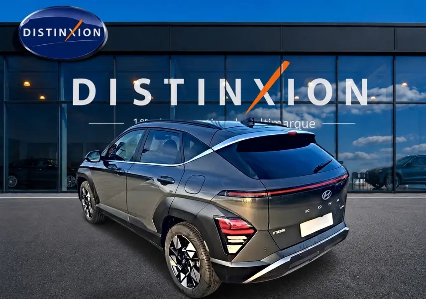 Vue 3/4 arrière droite d’un Hyundai Kona 2025 gris ecotronic avec jantes alliage et bande lumineuse arrière LED.