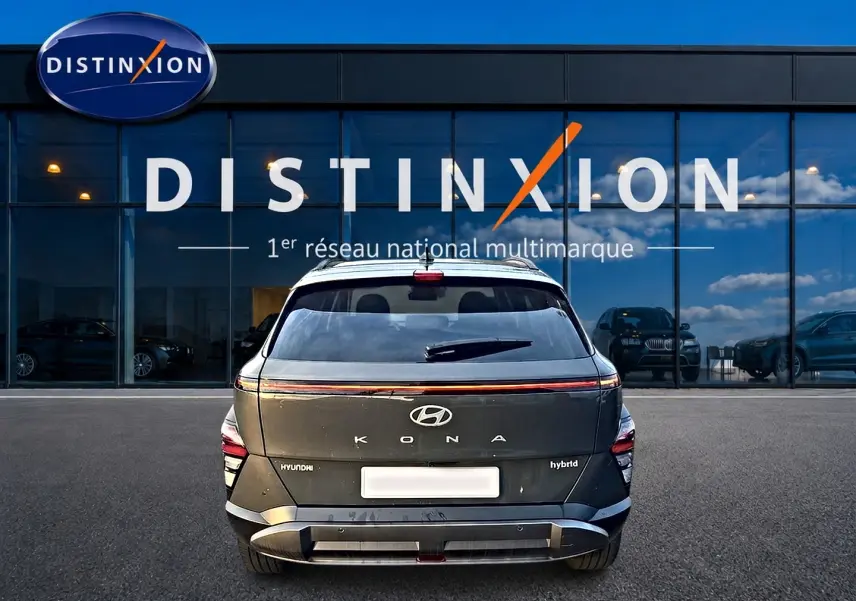 Vue arrière d'un Hyundai Kona hybride gris ecotronic devant une vitrine avec logo Distinxion.