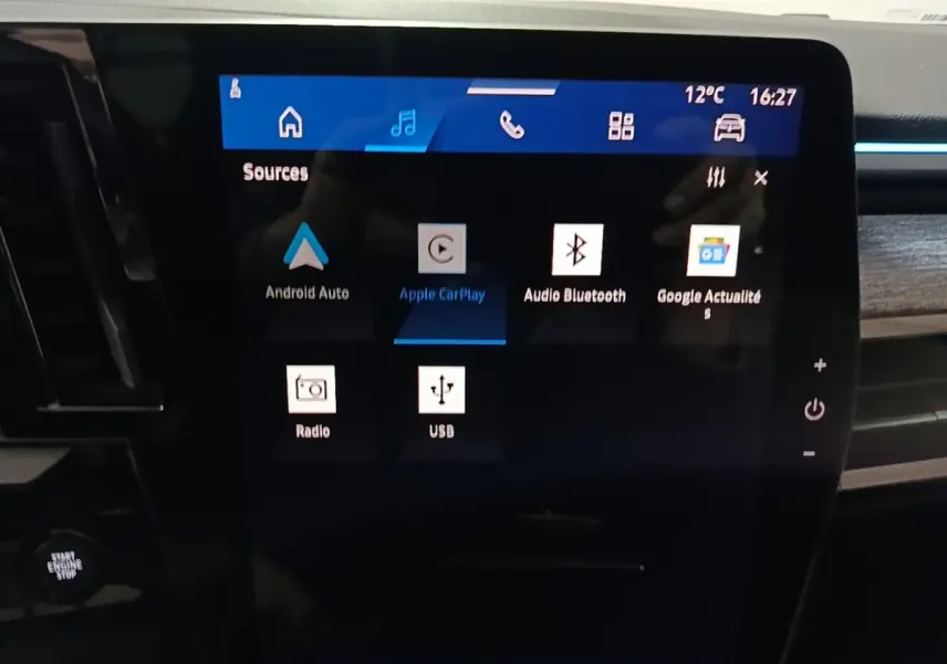 Écran tactile central du tableau de bord du Renault Austral bleu, affichant les options multimédias connectées.