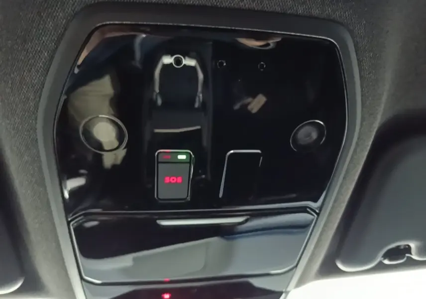Vue en gros plan du plafonnier intérieur noir du Renault Austral 2024 avec bouton SOS lumineux rouge.