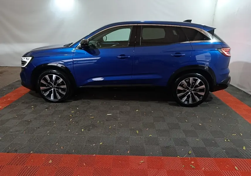 Renault Austral bleu en profil côté gauche, avec jantes alliage noires et toit noir contrasté.