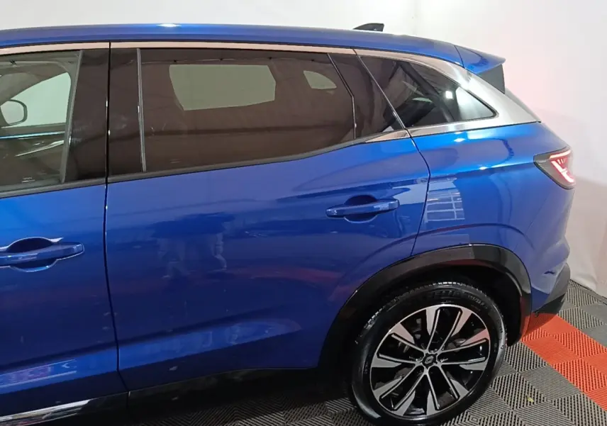 Vue latérale droite du Renault Austral bleu 2024, mettant en valeur la ligne de caisse et la jante alliage noire et argent.