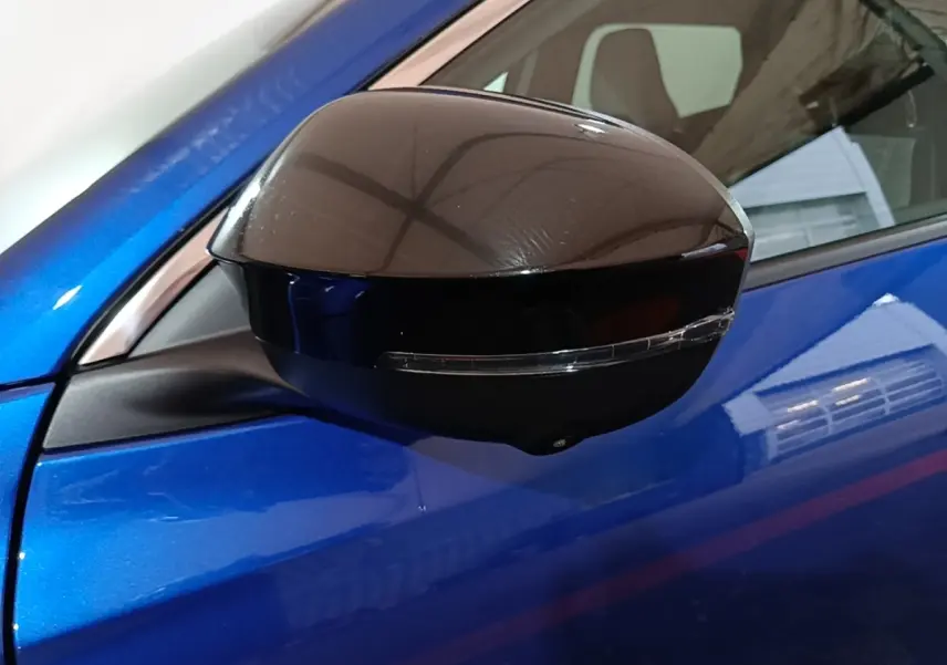 Rétroviseur droit noir brillant avec clignotant intégré sur Renault Austral bleu électrique, vue rapprochée côté conducteur.