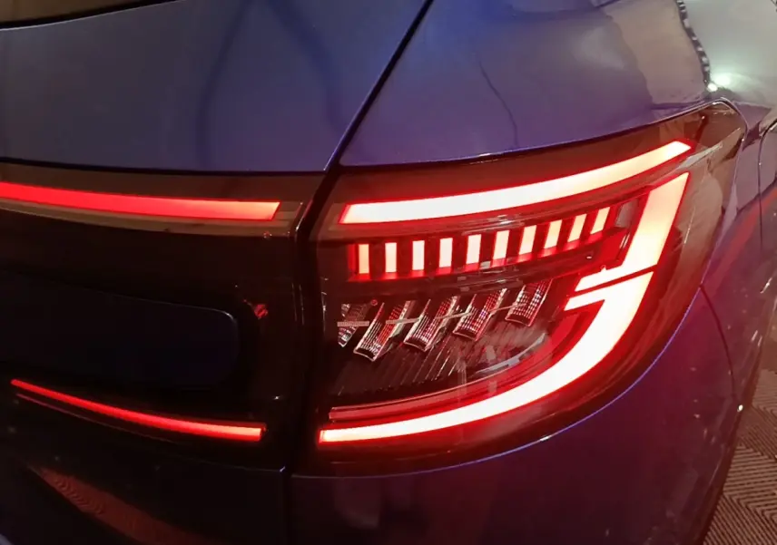Gros plan sur le feu arrière droit rouge allumé du Renault Austral bleu 2024, soulignant son design lumineux distinctif.
