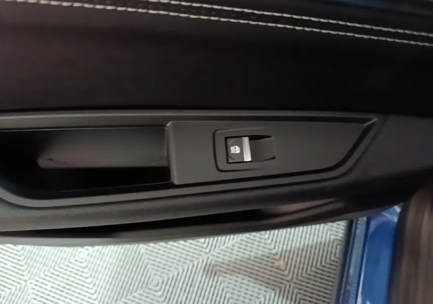 Détail de la commande d'éclairage sur la porte côté conducteur du Renault Austral bleu 2024, intérieur noir.